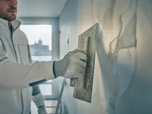 Ouvrier appliquant le plâtre sur une façade